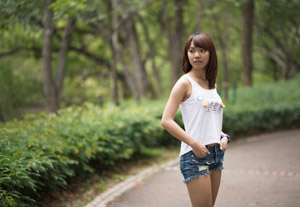 デニムのショートパンツのポケットに手を入れる女性