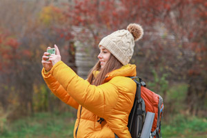 フリー写真 スマホで写真を撮る冬のハイキング中の外国人女性