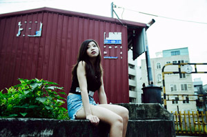 フリー写真 建物の前のコンクリートの上に座る台湾人女性