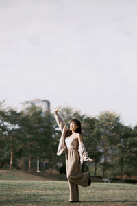 フリー写真 片足を上げて芝生の上に立つ台湾人女性