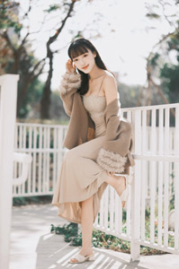 フリー写真 柵の前で片足を上げる台湾人女性