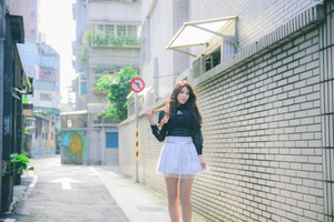 フリー写真 髪先を持って路地に立つ台湾人女性