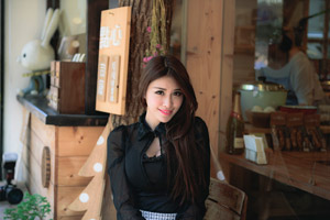 フリー写真 店の前のテラス席に座る台湾人女性