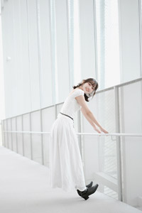 フリー写真 フェンスの前の手すり捕まってつま先を上げる台湾人女性