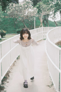 フリー写真 両手を後ろにして前かがみにある台湾人女性