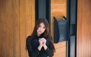 フリー写真 木製の壁の前で手を組む台湾人女性