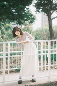 フリー写真 フェンスの前で体を横に傾ける台湾人女性