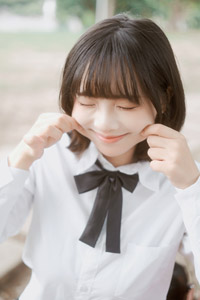 フリー写真 ほっぺに指を当てる女子学生