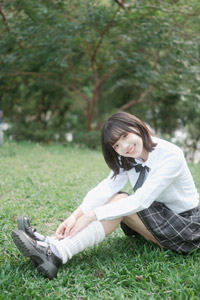 フリー写真 草の上に座る女子学生