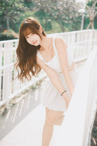 フリー写真 フェンスにつかまって片足を上げる台湾人女性