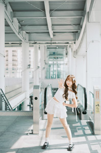 フリー写真 エスカレーターの前でストップのポーズの台湾人女性