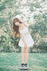 フリー写真 髪を耳にかけながらかがむ台湾人女性