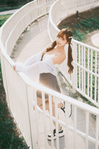 フリー写真 手すりにつかまって片足を上げるツインテールの台湾人女性