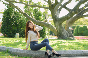 フリー写真 公園の木と花壇の淵に座る台湾人女性
