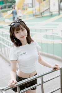 フリー写真 サングラスを頭にかけて鉄柵の前に立つ台湾人女性