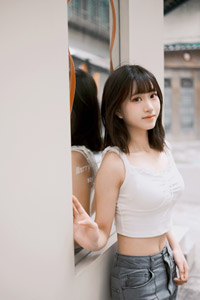フリー写真 ショート丈のタンクトップ姿で鏡の前に立つ台湾人女性