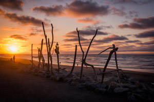 フリー写真 木の棒で作られた「HOKITIKA」と夕暮れのビーチ