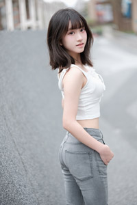 フリー写真 後ろを振り返るタンクトップとジーンズ姿の台湾人女性