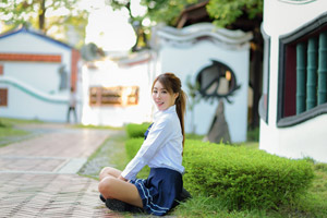 フリー写真 あぐらをかいて座る学生服姿の女子学生