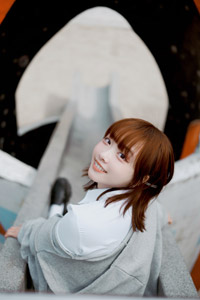 フリー写真 すべり台の座って振り返る台湾人女性
