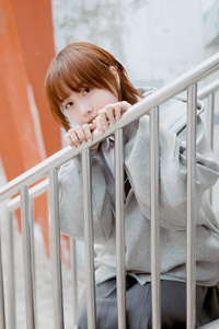 フリー写真 階段の手すりに手をかけてしゃがむ台湾人女性