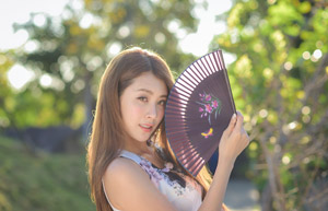 フリー写真 顔の近くで扇子を開く台湾人女性
