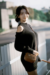 フリー写真 ニットを着て鞄をたすき掛けした台湾人女性