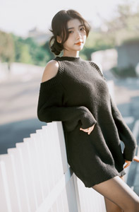フリー写真 黒いニットを着て白いフェンスに寄り掛かる台湾人女性