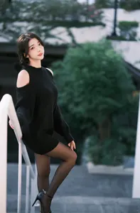 フリー写真 黒のニット姿で階段の手すりの側に立つ台湾人女性