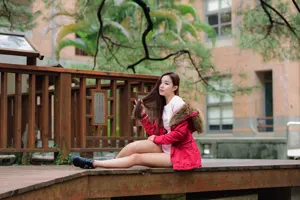 フリー写真 髪を持ち上げながらウッドデッキの上に座る台湾人女性