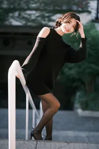フリー写真 階段の手すりにつかまりながら手をかざす台湾人女性
