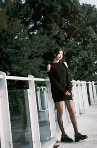 フリー写真 黒のニットを着てフェンスの前に立つ台湾人女性