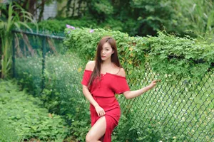 フリー写真 草が生い茂ったフェンスの前に立つ台湾人女性