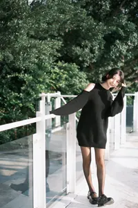 フリー写真 フェンスにつかまって体を横に倒す台湾人女性