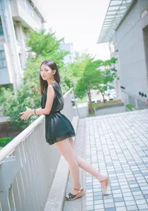 フリー写真 黒いミニワンピースを着てフェンスの前に立つ台湾人女性
