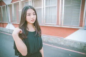 フリー写真 指で髪を触りながら道路に立つ台湾人女性