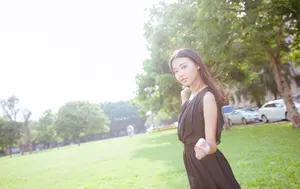 フリー写真 黒の服を着て公園の芝生の上に立つ台湾人女性