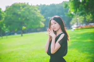 フリー写真 指を合わせて芝生の上に立つ台湾人女性