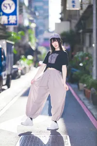 フリー写真 手でズボンを広げながら片足を上げる台湾人女性