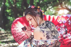 フリー写真 お猪口を持つ背中に中の刺青があるアジア人女性