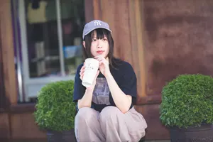 フリー写真 飲み物を持ってしゃがむ台湾人女性