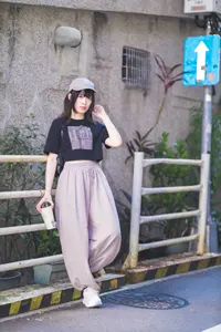 フリー写真 鉄柵にもたれかかるキャップを被った台湾人女性