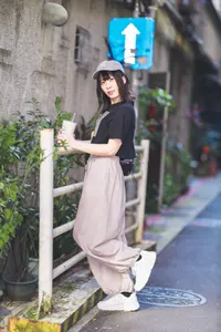 フリー写真 飲み物を持って鉄柵の前に立つ台湾人女性