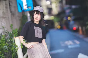 フリー写真 グレーのキャップを被って鉄柵の側に立つ台湾人女性
