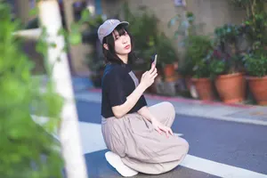 フリー写真 スマホを持って路地にしゃがむ台湾人女性