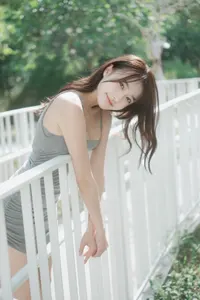 フリー写真 しろい柵によりかかるキャミワンピ姿の台湾人女性