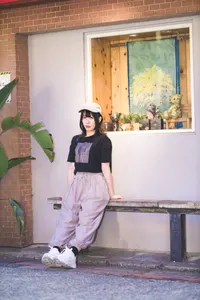 フリー写真 建物の前のベンチに腰掛ける台湾人女性