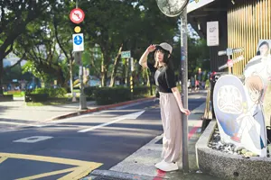 フリー写真 カーブミラーの下で敬礼する台湾人女性