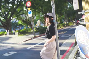 フリー写真 カーブミラーのポールにもたれかかる台湾人女性