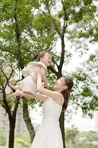 フリー写真 戸外で赤ちゃんを抱き上げるママ
